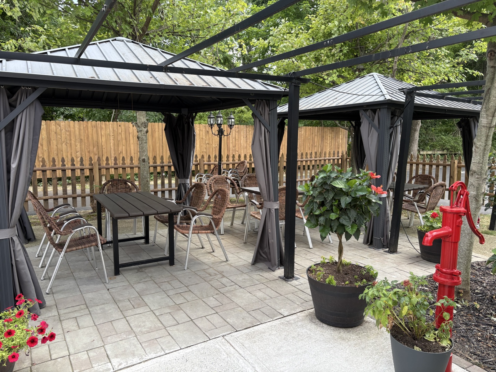 Smoky Rock BBQ daytime patio with shaded canopy tables and flowering planters